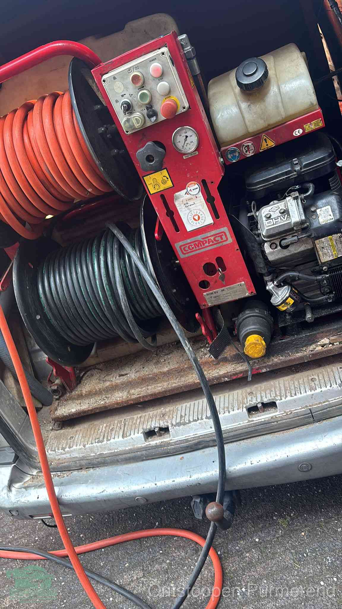 Een rood hogedruk-rioolreinigingstoestel in de laadbak van de bedrijfsbus, apparatuur voor een hardnekkige afvoerverstopping in Purmerend