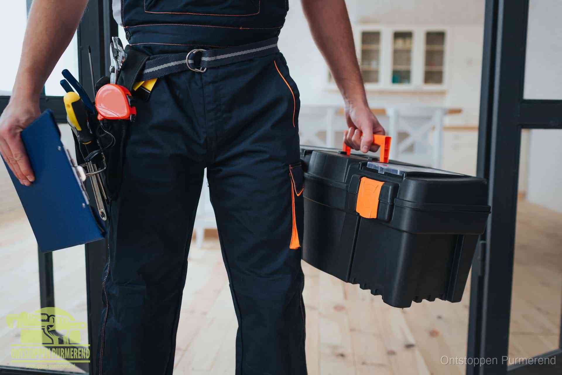 Een monteur met gereedschapsriem en klembord in een keuken, klaar om een transparante prijs voor het gootsteen ontstoppen in Purmerend te geven