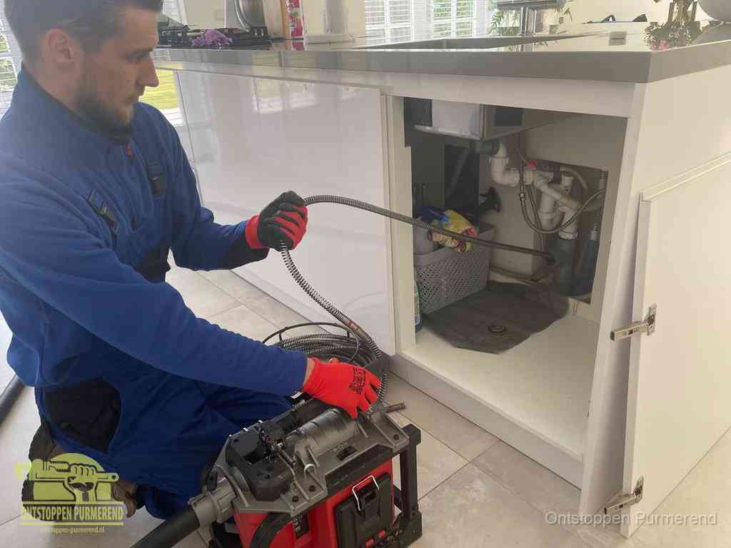 Een monteur reinigt de keukenafvoer grondig met een veermachine om terugkerende gootsteenverstoppingen te voorkomen in Purmerend